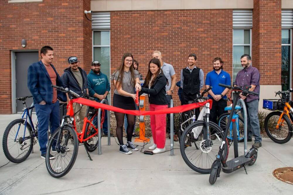 Students cut a ribbon in front of the new E-Mobility Charging stations.