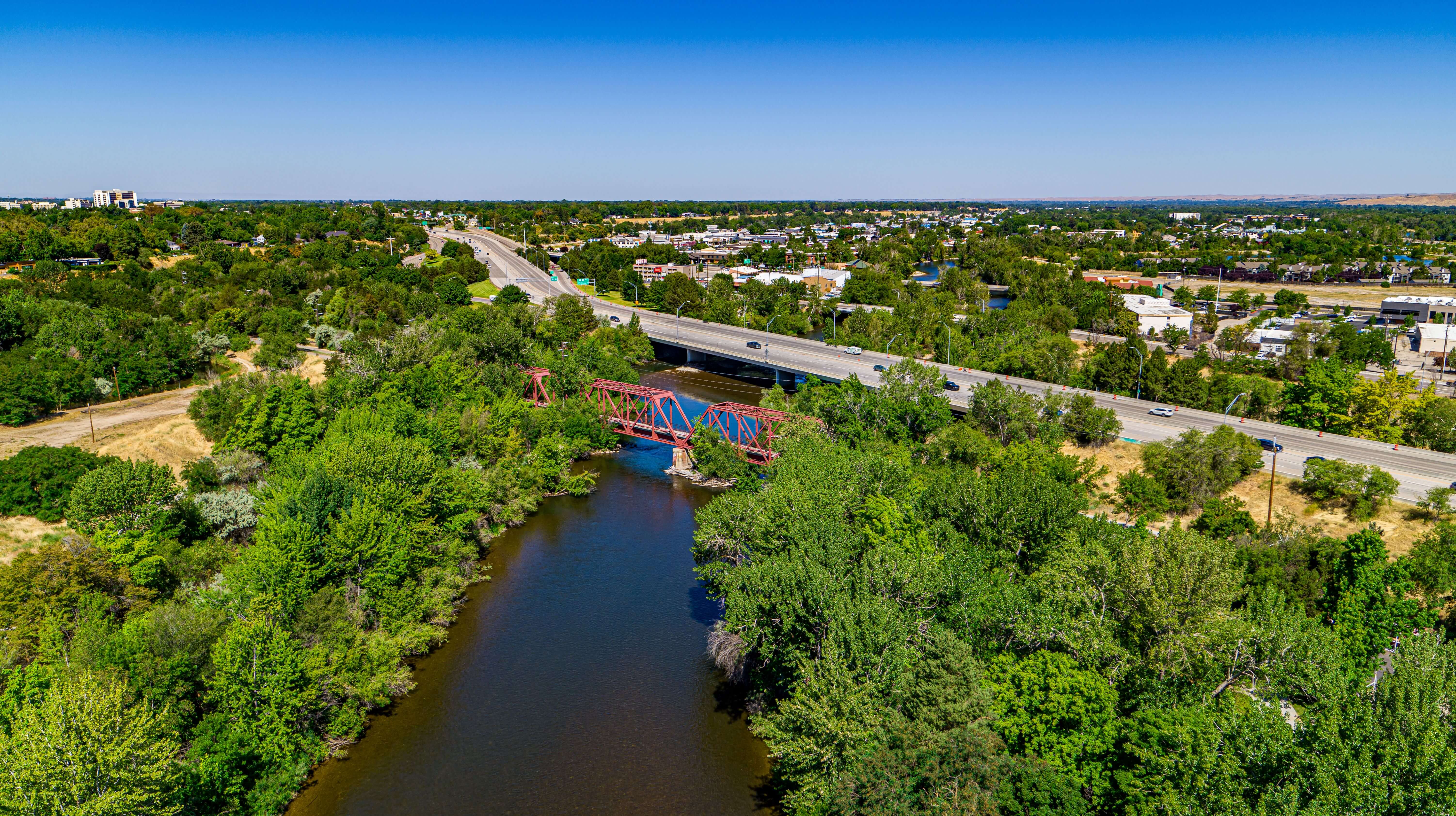 Arial view of Boise river lined with trees with adjacent roadway.