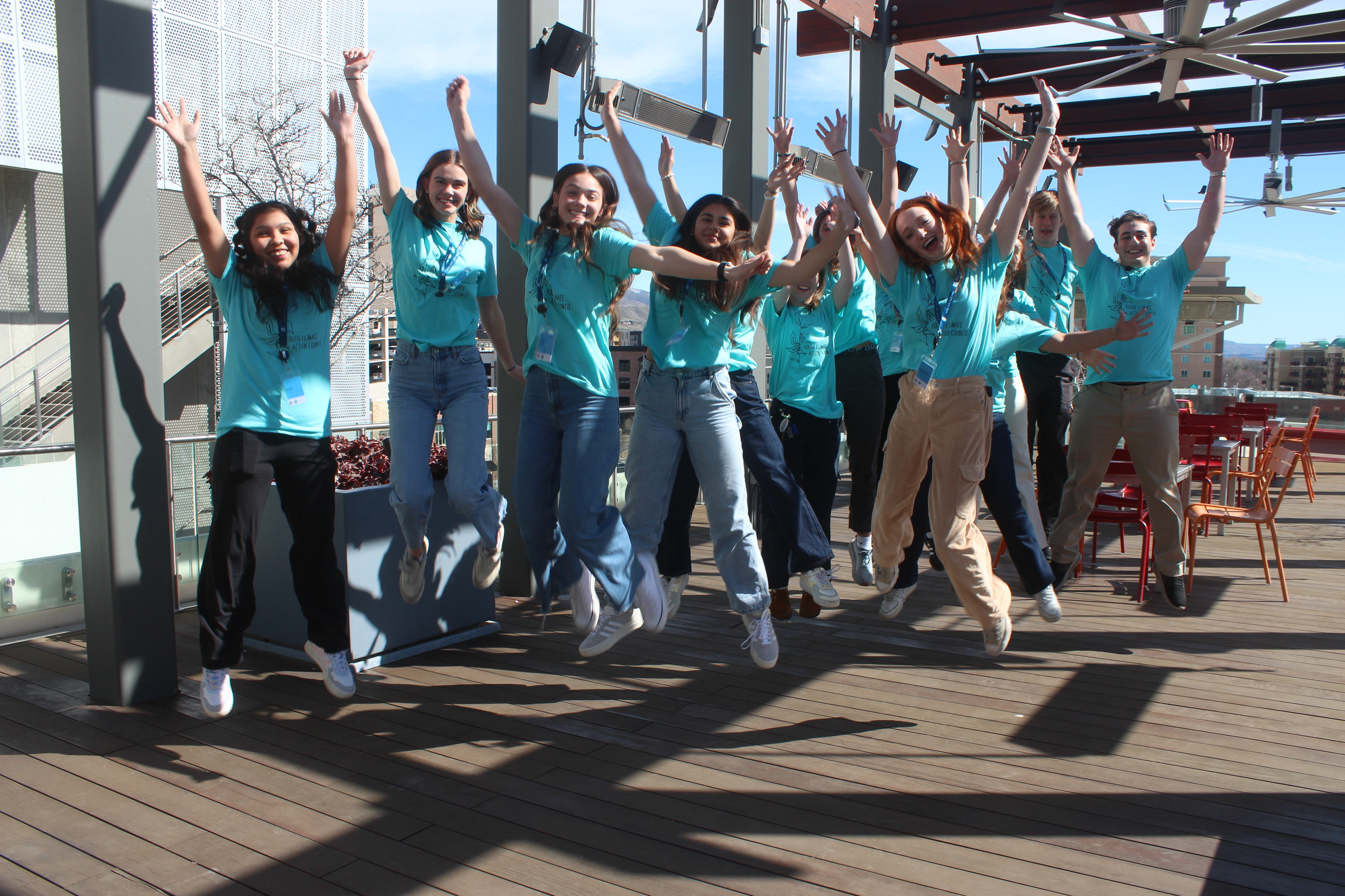 YCAC group leaps with hands overhead.