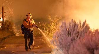 Firefighter putting out fire brushfire