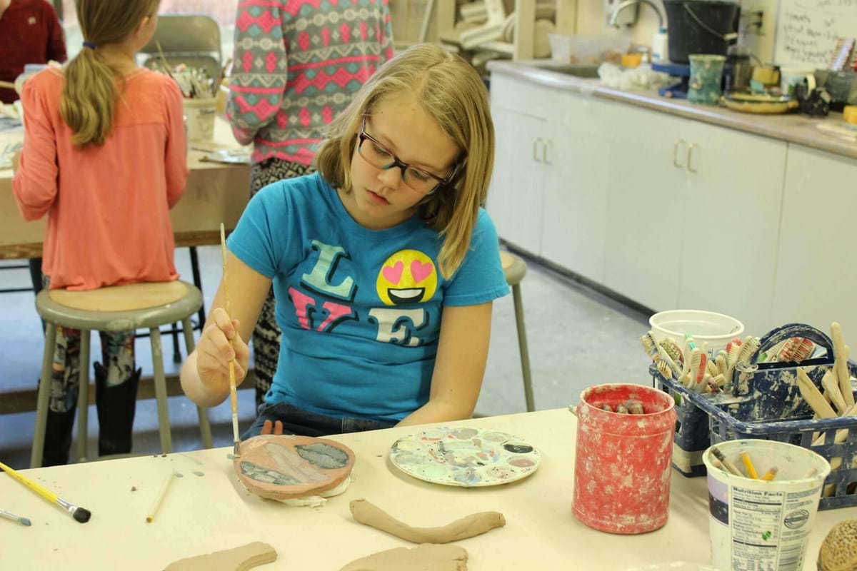 Girl painting pottery