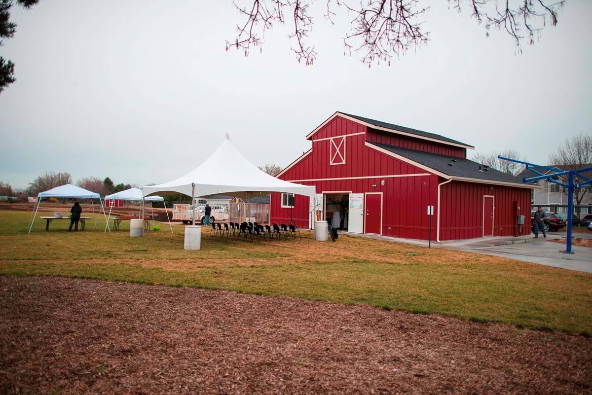 Red barn at park with white canopy and gray skies