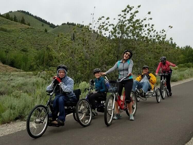 Adventure participants on bicycles on the greenbelt on an overcast day.