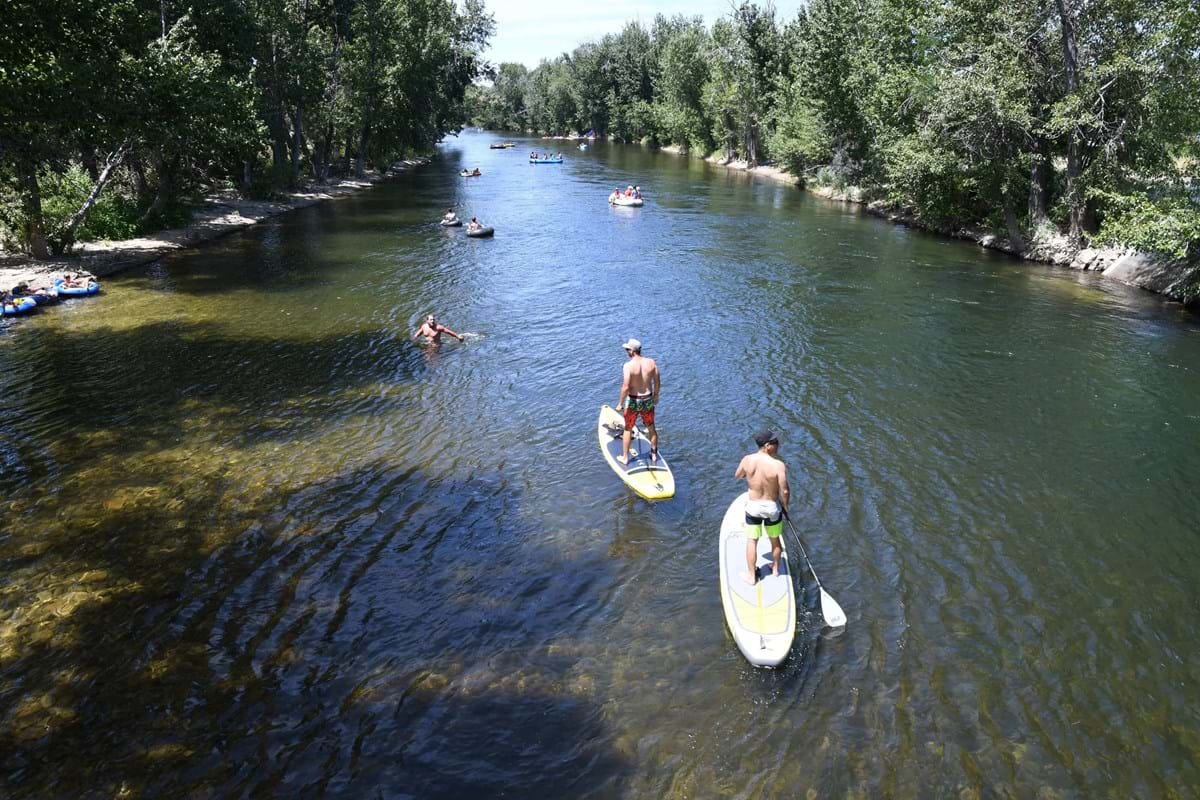 Paddleboards and boats on the Boise River on a warm summer day