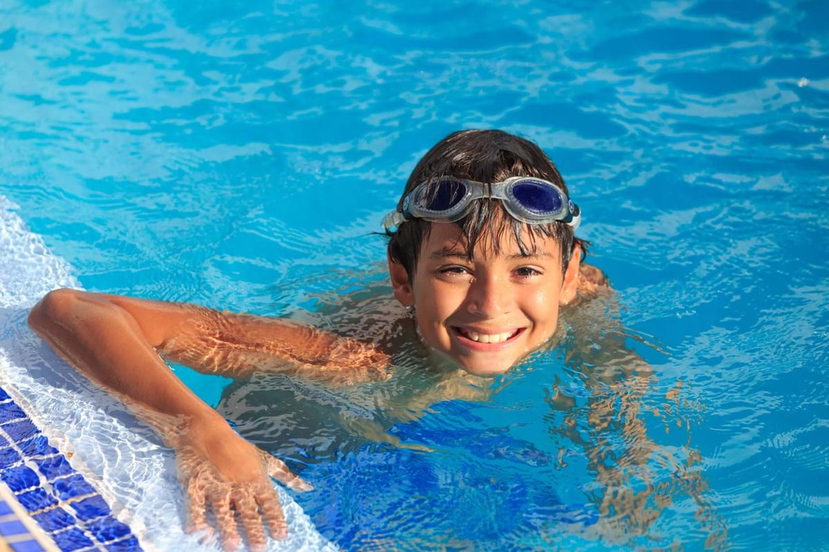 young boy swimming at the pool