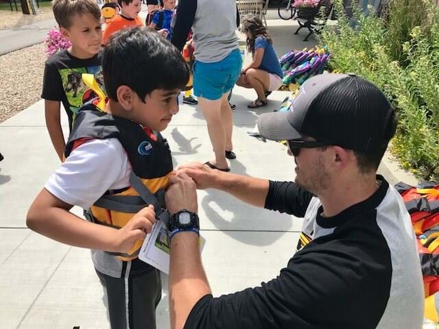 boy getting help with life jacket
