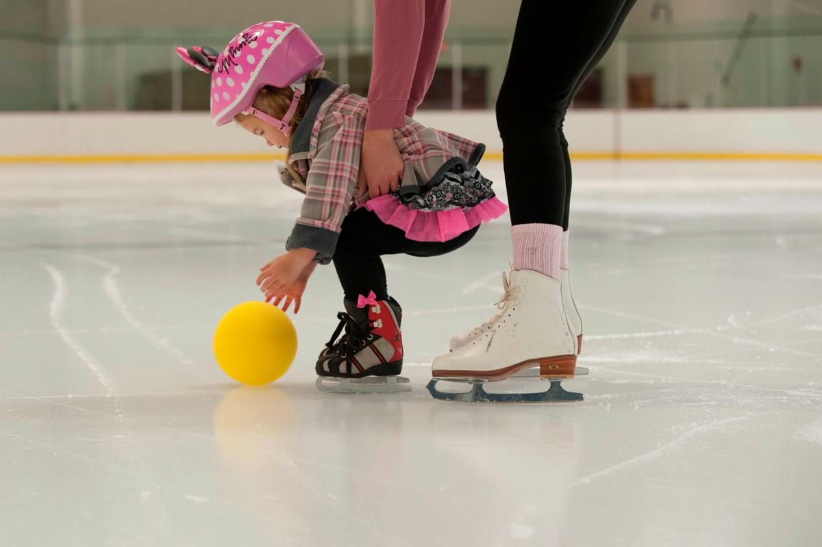 Young girl learning how to skate on ice